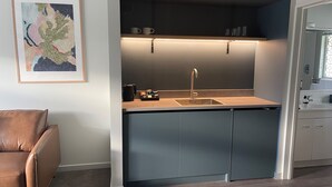 Una cocina moderna con un lavamanos integrado, una cafetera y una encimera.