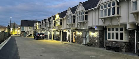 A row of traditional-style buildings with stone facades and pitched roofs, likely part of a hotel or residential complex.