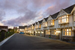 Una hilera de edificios de estilo tradicional, con detalles de piedra y múltiples ventanas, probablemente parte de un hotel o complejo residencial.