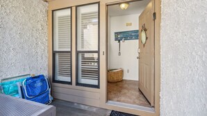 A hotel entrance with a door leading to a room. There is a blue bag and a wheelchair near the entrance. - Dogs Welcome! Pool access. 1 Block to beach! Serene retreat under a majestic old oak canopy (Fernandina Beach)