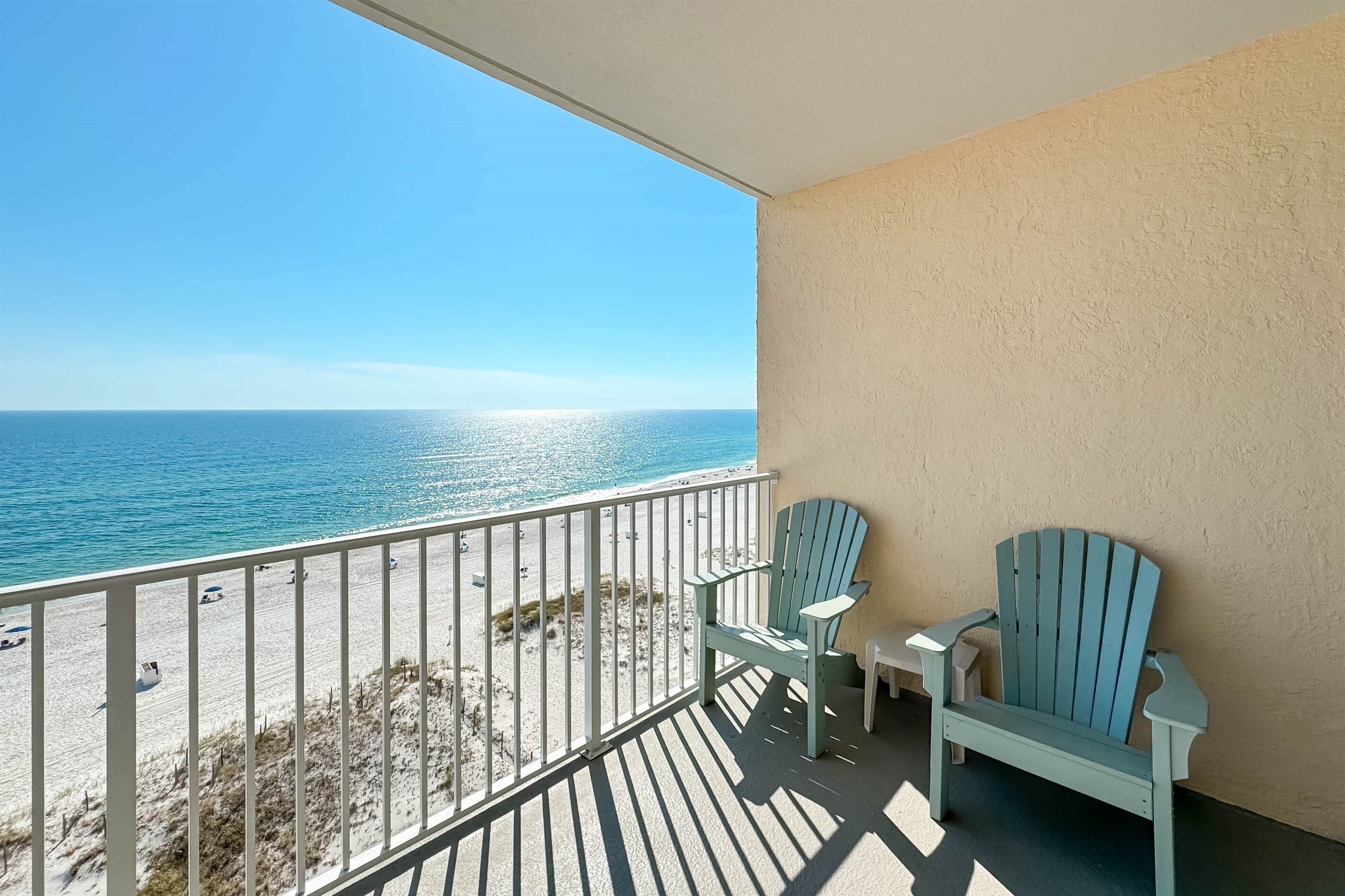 A balcony with a view of the beach and ocean.