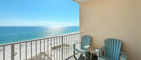 A balcony with a view of the beach and ocean.