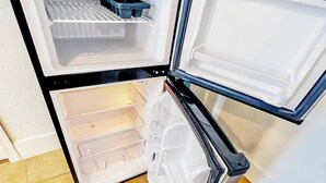 An open refrigerator with two shelves and a freezer compartment.