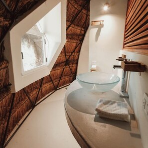 A modern bathroom with a glass bowl sink, a window, and a wooden slatted wall. - Ekumal Retreat Eco Sanctuary (Akumal)