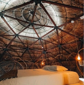 A room with a thatched ceiling and a bed with pillows. - Ekumal Retreat Eco Sanctuary (Akumal)