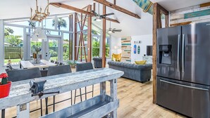 A spacious kitchen with a large refrigerator, wooden beams, and a dining area with a rustic table. - Surf House Cocoa Beach...Family-Friendly, Walk to Beach! (Cocoa Beach)