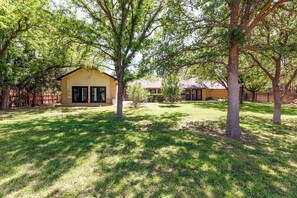 A residential area with a house, a well-maintained lawn, and several trees. - Peaceful Retreat near Texas Tech with Epic Game room! (Lubbock)