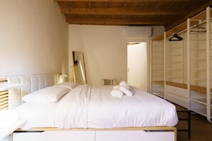 A bedroom with a bed, a chair, a wardrobe, and a mirror. - Modern residence with balconies overlooking Piazza Erbe (Verona)
