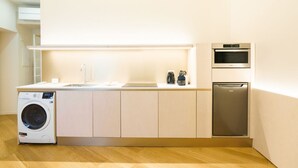 A modern kitchen with a washing machine, a dishwasher, and an oven.