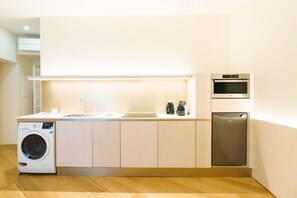 A modern kitchen with a washing machine, a dishwasher, and an oven.