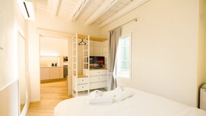Quarto com cama, guarda-roupa, banheiro e cozinha.