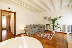A modern living room with a sofa, a coffee table, a rug, and a potted plant.