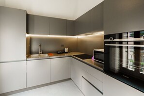 A modern kitchen with built-in appliances, a sink, and a countertop. - Spacious and bright penthouse with 3 small balconies (Verona)