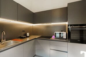 A modern kitchen with a built-in microwave, oven, and a sink. - Spacious and bright penthouse with 3 small balconies (Verona)