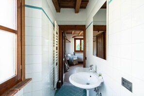 A narrow bathroom with white tiles, a wooden ceiling, and a large window. - Merici residence, elegant and fairytale-like (Verona)