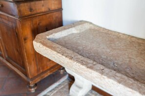 Un aparador de madera con cajones y una encimera de mármol.