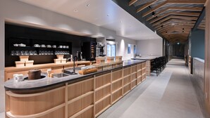 A modern kitchen with a long island, wooden cabinetry, and a sleek countertop.