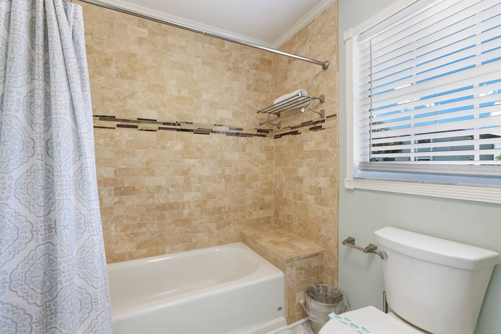 Een badkamer met een bad, toilet en douche.