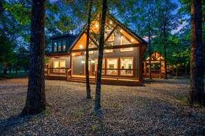 Eine Holzhütte mit großer Terrasse, zahlreichen Fenstern und einer Holzfassade.