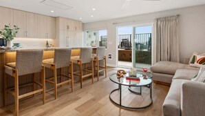 A modern apartment with a kitchen, dining area, and living room.