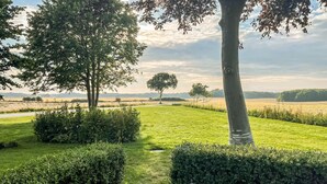 Un giardino curato con siepi ordinate e alberi maturi, che offre un'oasi di tranquillità all'aperto.
