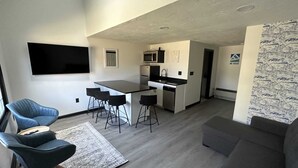 Ein modernes Apartment mit Küche, Essbereich und Wohnzimmer.