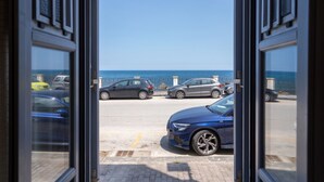 A view through a doorway to a parking area with cars and a clear blue sky.