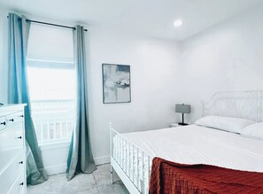 Relax in this serene bedroom with a single bed, bedside table, and wall-mounted art.