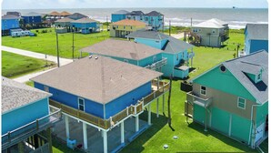 A coastal residential area with houses featuring balconies and a view of the ocean. - Elegant home 180 steps from the Beach, 2 King beds, Arcade (Bolivar Peninsula)