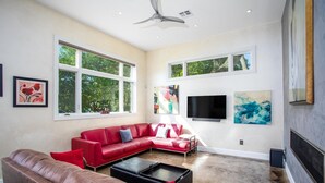 A spacious living room with a red sectional sofa, a brown leather couch, and a black coffee table. - Sta-Haus | Wonderful Location (Fredericksburg)