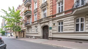 A historic building with a classic facade, ornate architectural details, and a prominent entrance. - Żwirki i Wigury Apartment #2 (Katowice)