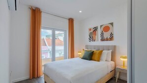 Une chambre d’hôtel moderne, dotée d’un grand lit, de deux lampes de chevet et offrant une vue sur le paysage urbain par la fenêtre.