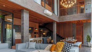 A spacious living area with a sectional sofa, ottomans, and a dining table.
