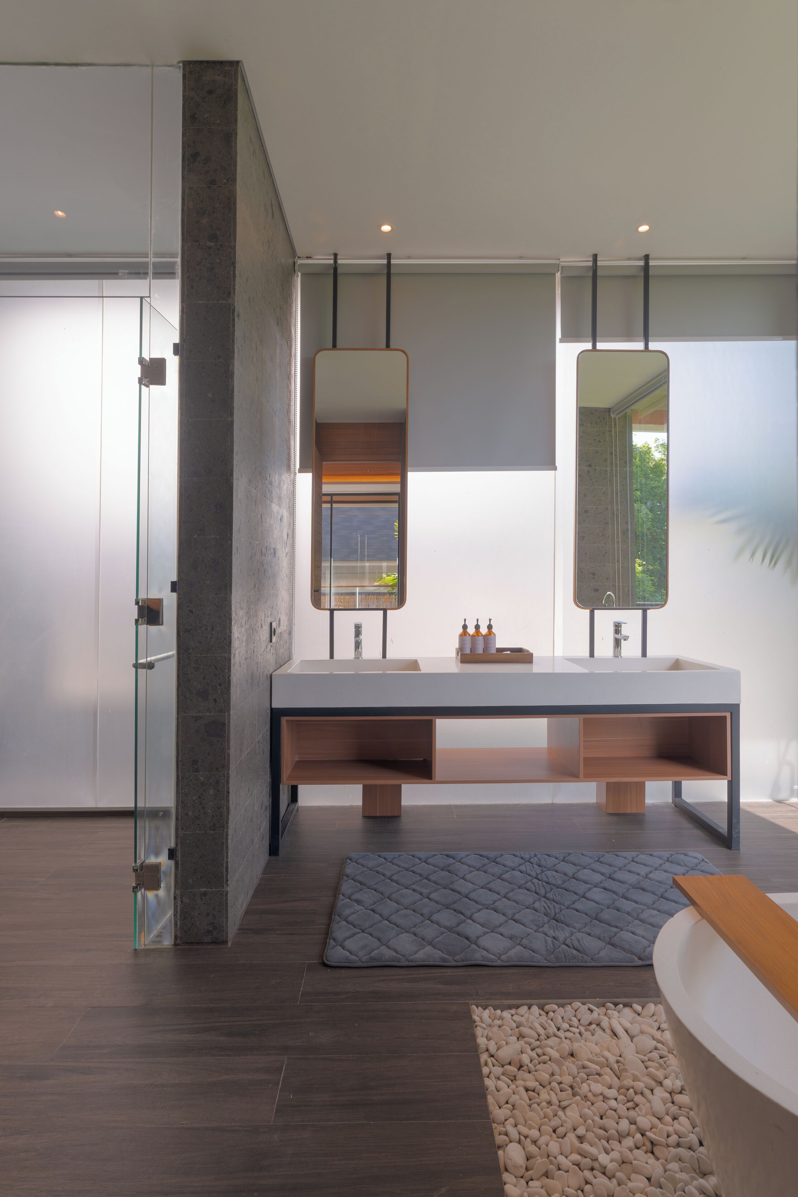 A modern bathroom with a large mirror, a bathtub, and a glass shower enclosure.