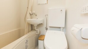 Ein kleines, sauberes Badezimmer mit Toilette, Waschbecken und Dusche.