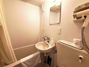 Ein Badezimmer mit Waschbecken, Spiegel, Haartrockner und Pflegeprodukten.