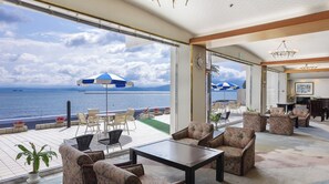 Ein geräumiger Balkon mit Sitzgelegenheit im Freien, Meerblick und ein modernes Interieur mit Essbereich.