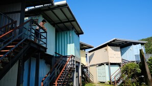 A series of shipping containers repurposed as buildings with external staircases. - The Reef (Lyudao)