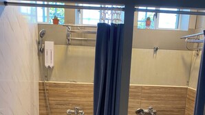 A modern bathroom with two shower stalls, wooden paneling, and a tiled floor. - The Reef (Lyudao)
