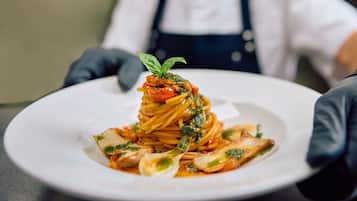 A plate of spaghetti with a garnish of basil, served on a white plate.
