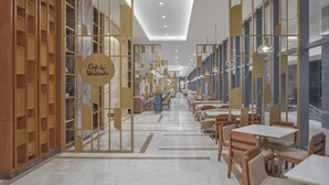 Un café moderno con mobiliario de madera, una zona de estar central y un letrero que dice 'Cafe by Westride'.
