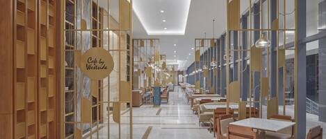 Un café moderno con mobiliario de madera, una zona de estar central y un letrero que dice 'Cafe by Westride'.