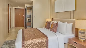 A hotel room with a large bed, a bedside table with a lamp, a wardrobe, and a mirror on the wall.