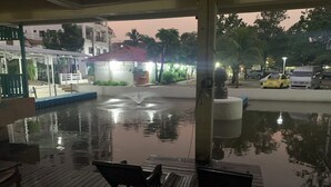 Zona de piscina al aire libre con bancos y una fuente.