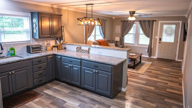 A modern kitchen with dark cabinets, a granite countertop, and a central island. -  Cozy country home with a beautiful creek at the back of the property.  (Mulberry)