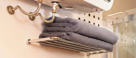 A towel rack with a folded towel against a wall.