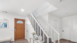 A staircase with white railings leading to a landing. - Super Spacious Family Vacation Home! (San Diego)
