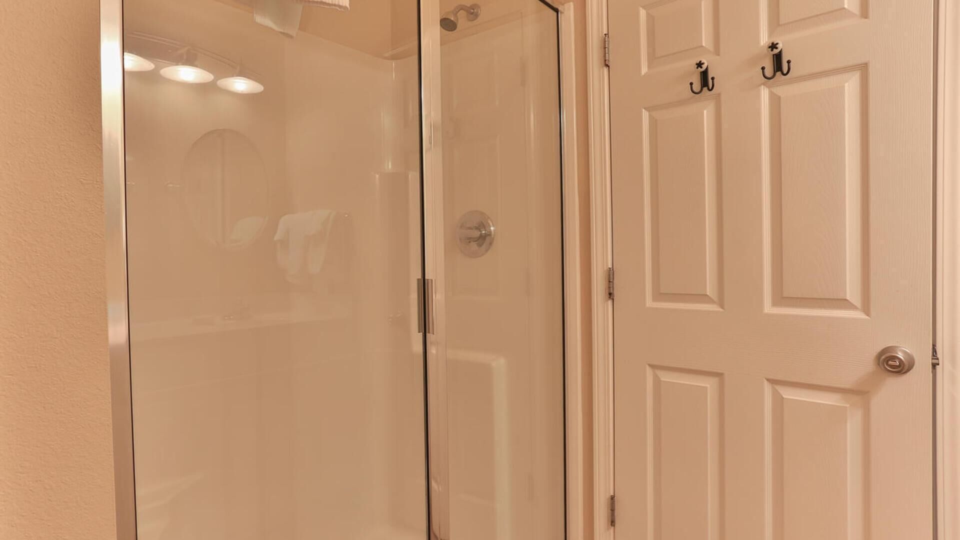 A hallway with a glass door leading to a room, a white door with a handle, and a door with a keyhole.