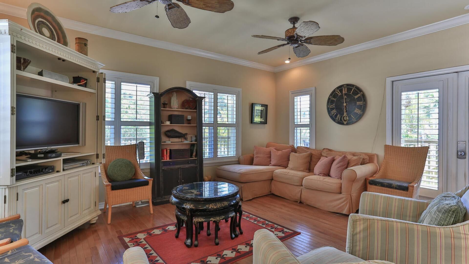 A living room with a television, a sofa, a coffee table, and a bookshelf.