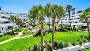 Ein modernes Hotel mit Innenhof, Palmen und Pool.